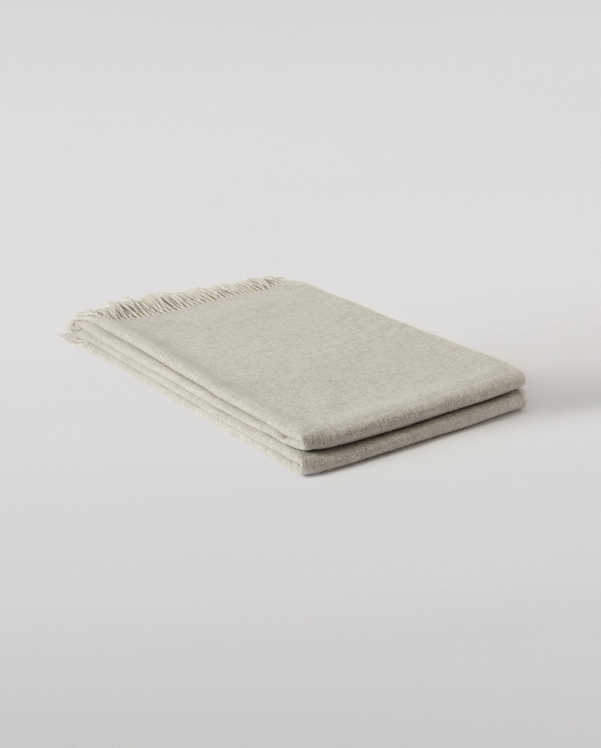 Johnstons of Elgin Interiors Collection Silver & White Reversible Cashmere Bed Throw on a white background  WA001374RU6322ONE