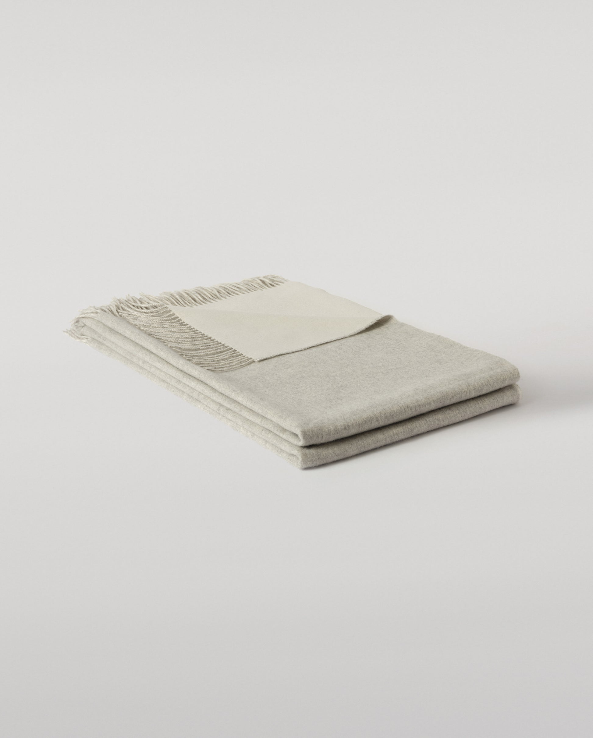 Johnstons of Elgin Interiors Collection Silver & White Reversible Cashmere Bed Throw on a white background  WA001374RU6322ONE