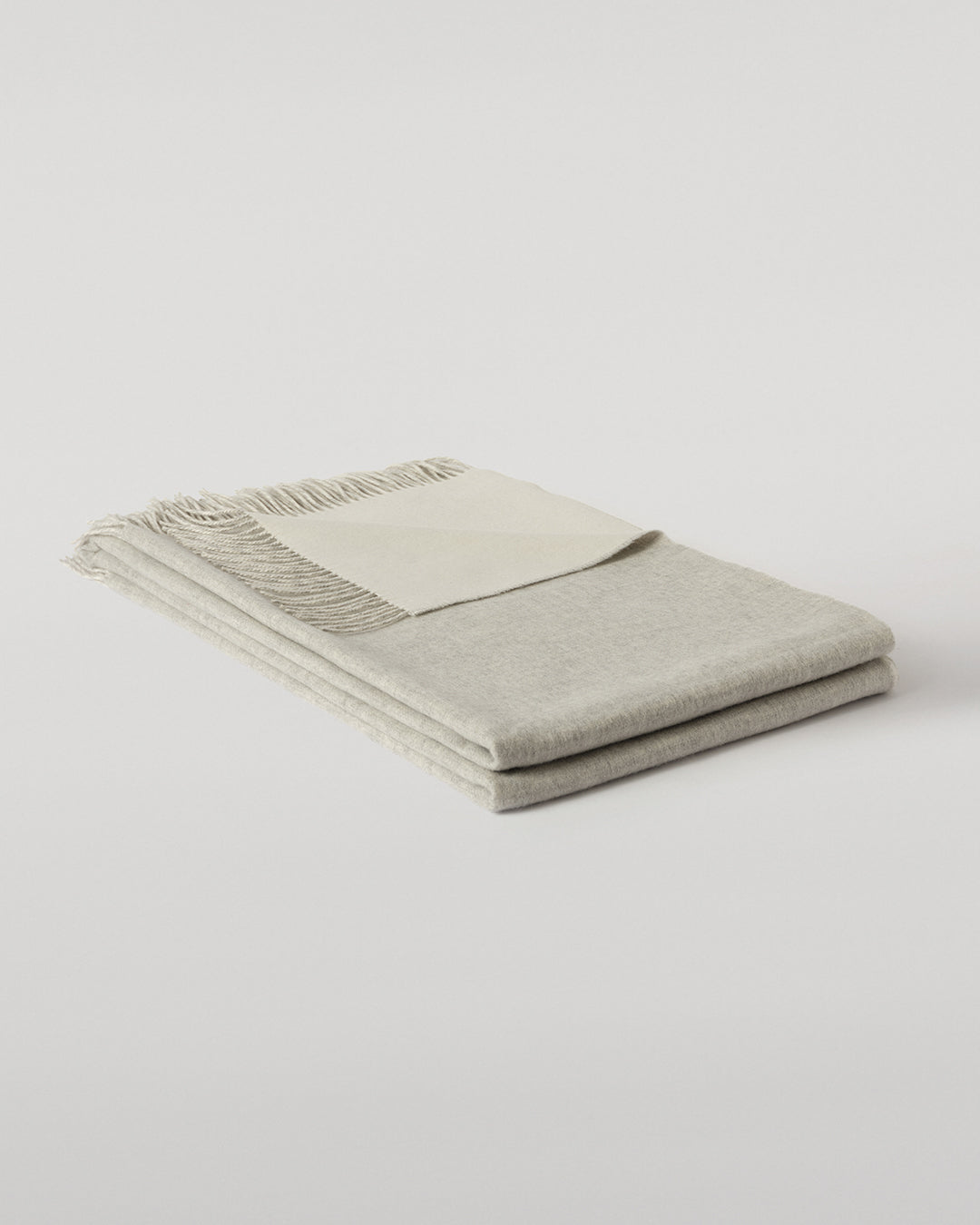 Johnstons of Elgin Interiors Collection Silver & White Reversible Cashmere Bed Throw on a white background  WA001374RU6322ONE