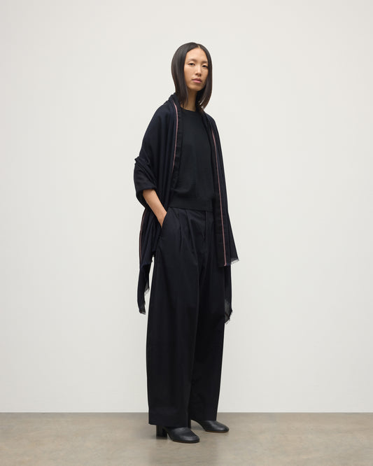 FEMALE MODEL WEARS JOHNSTONS OF ELGIN IVES CHEVRON BORDER SCARF NAVY 100% CASHMERE DRAPED OVER HER SHOULDERS OVER A NAVY CASHMERE SWEATER   WA002446RU7699ONE