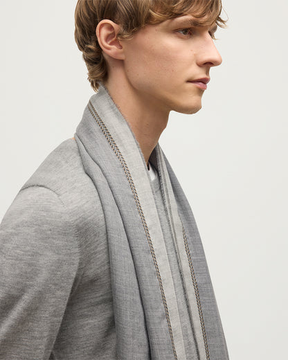 MALE MODEL WEARS JOHNSTON OF ELGIN IVES CHEVRON BORDER SCARF 100% CASHMERE OVER A GREY SUPERFINE CASHMERE SWEATER WA002446RU7700ONE