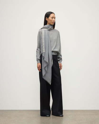 MODEL WEARS JOHNSTON OF ELGIN IVES CHEVRON BORDER SCARF 100% CASHMERE OVER A LIGHT GREY CASHMERE SWEATER WA002446RU7700ONE