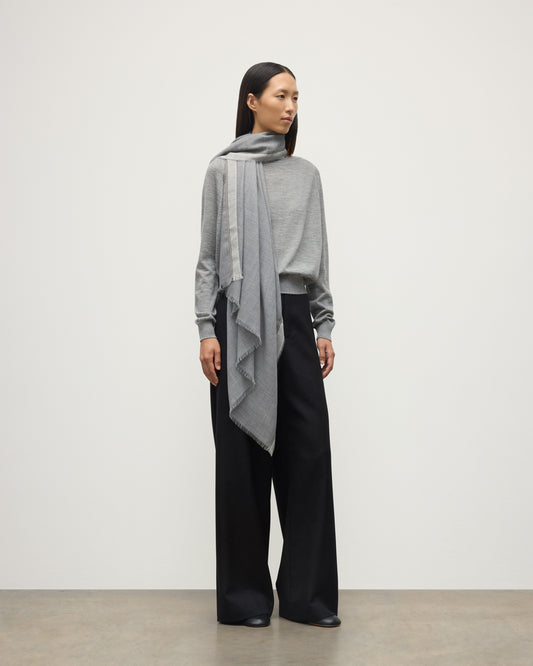 MODEL WEARS JOHNSTON OF ELGIN IVES CHEVRON BORDER SCARF 100% CASHMERE OVER A LIGHT GREY CASHMERE SWEATER WA002446RU7700ONE