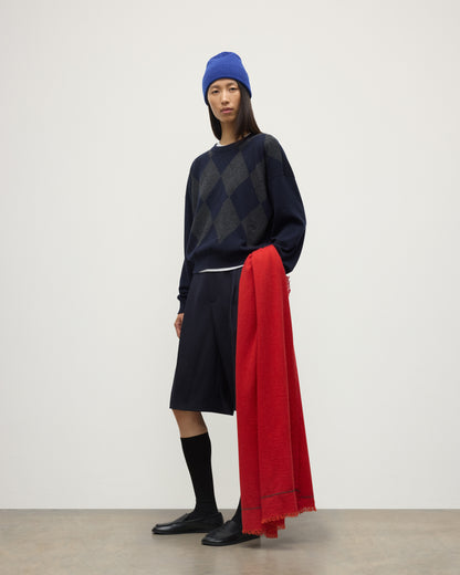 FEMALE MODEL WEARING JOHNSTONS OF ELGIN USAN SEMI PLAIN SCARF RED 100% CASHMERE WITH CLAN ARGYLL CASHMERE SWEATER, KILT AND BRAEMAR BLUE BEANIE WA002550RU7721ONE