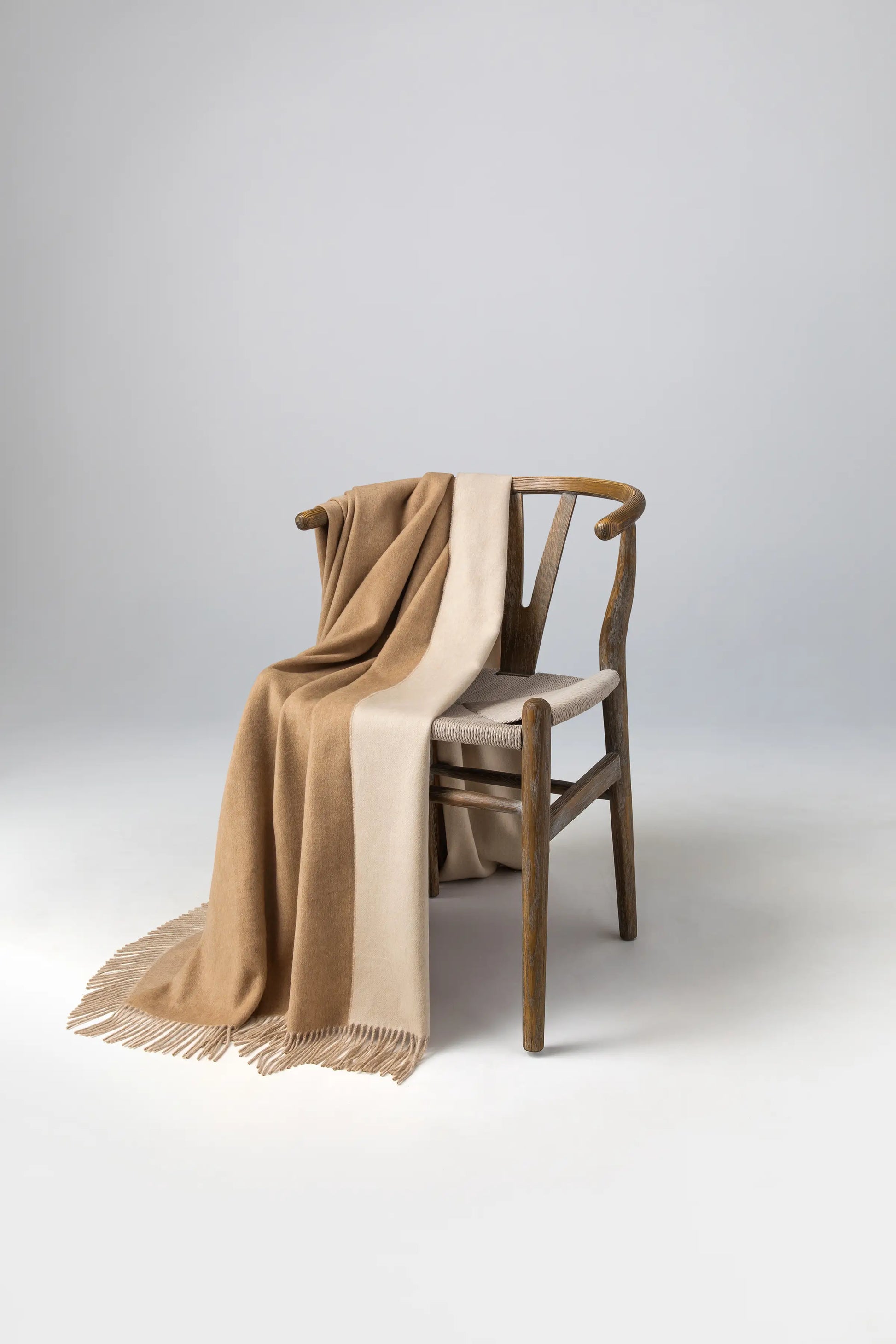 2025 Johnstons of Elgin Interiors Collection Blonde & White Reversible Cashmere Throw on a wooden chair   WA000013RU7432ONE