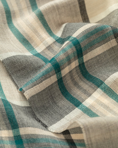 Close-up of a plaid fabric with green, gray, and beige colors. JOHNSTONS OF ELGIN ORTON CRAMMED TARTAN SCARF NEUTRAL 100% CASHMERE WA002447RU7702ONE