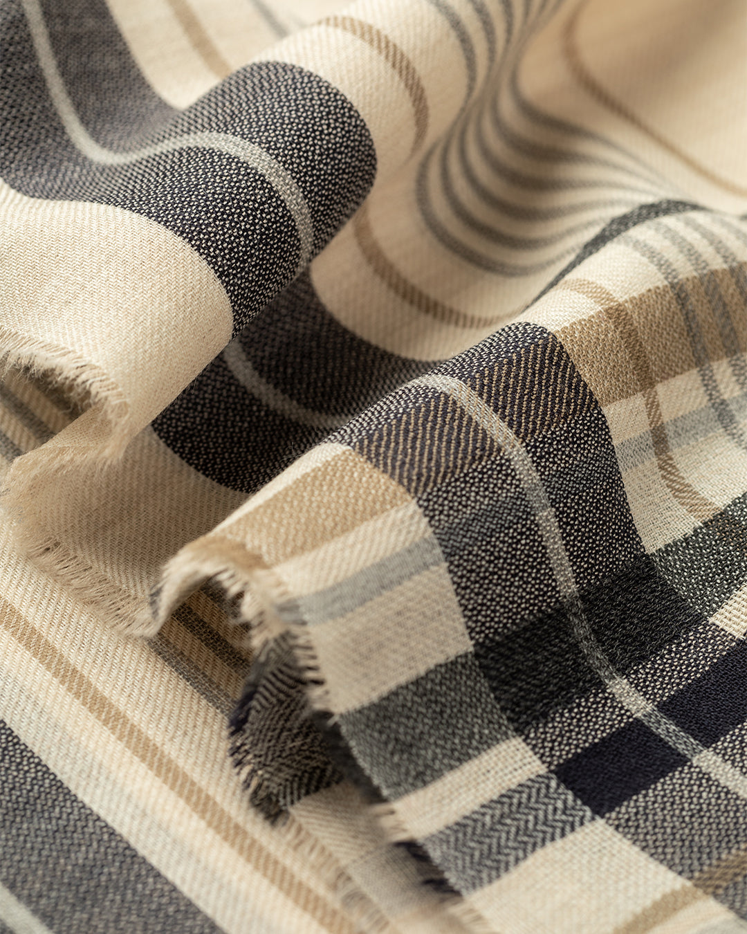 Close-up of a plaid fabric with beige, black, and brown colors. JOHNSTONS OF ELGIN HELMINA CRAMMED DETAIL BORDER SCARF NATURAL 100% CASHMERE WA002459RU7704ONE