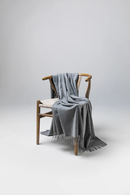 Johnstons of Elgin Blanket Collection Granite Plain Cashmere Throw on a wooden chair WA000055HA0300ONE