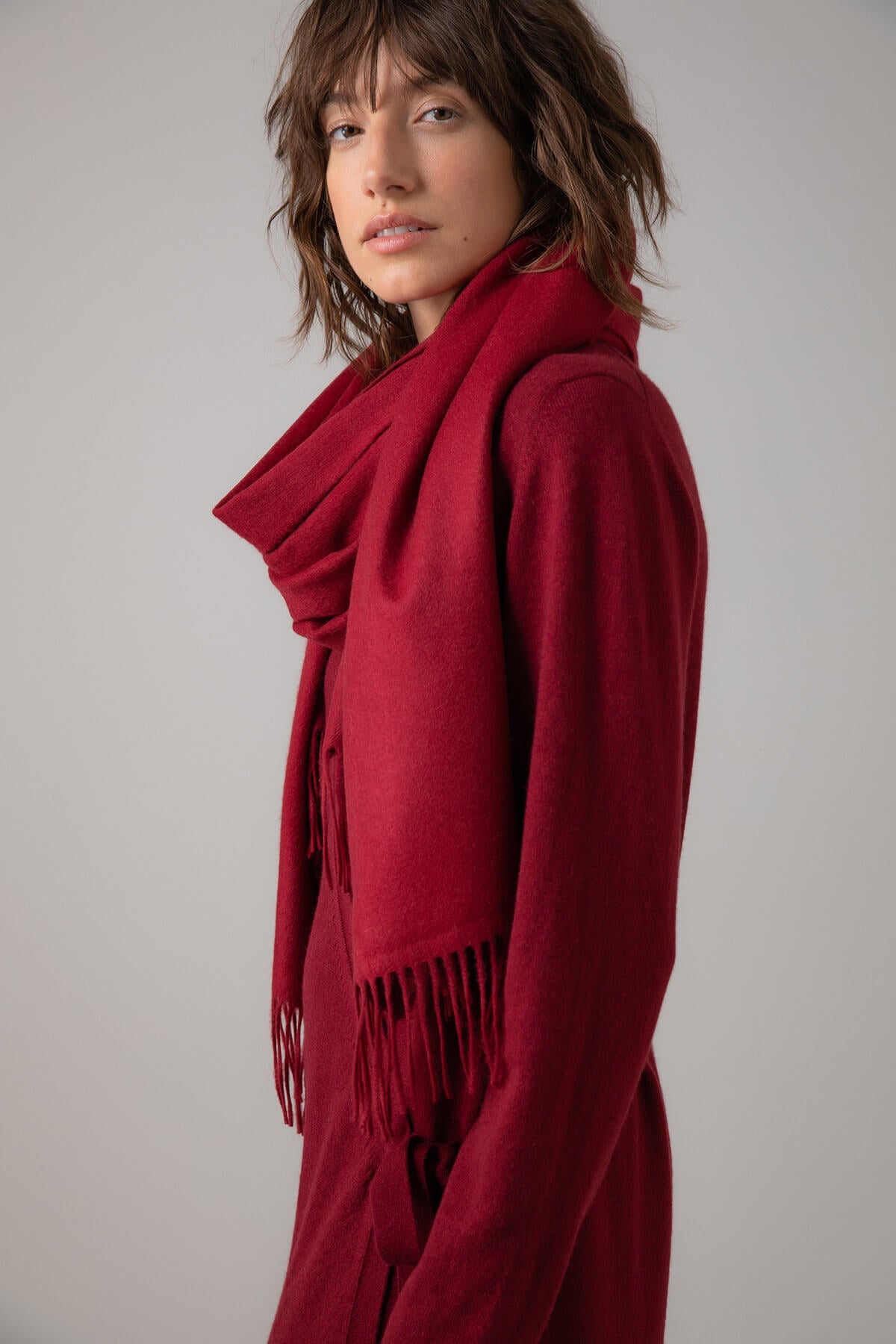 Model wearing Johnstons of Elgin 100% Cashmere Stole in Merlot on a grey background WA000056SE7234N/A