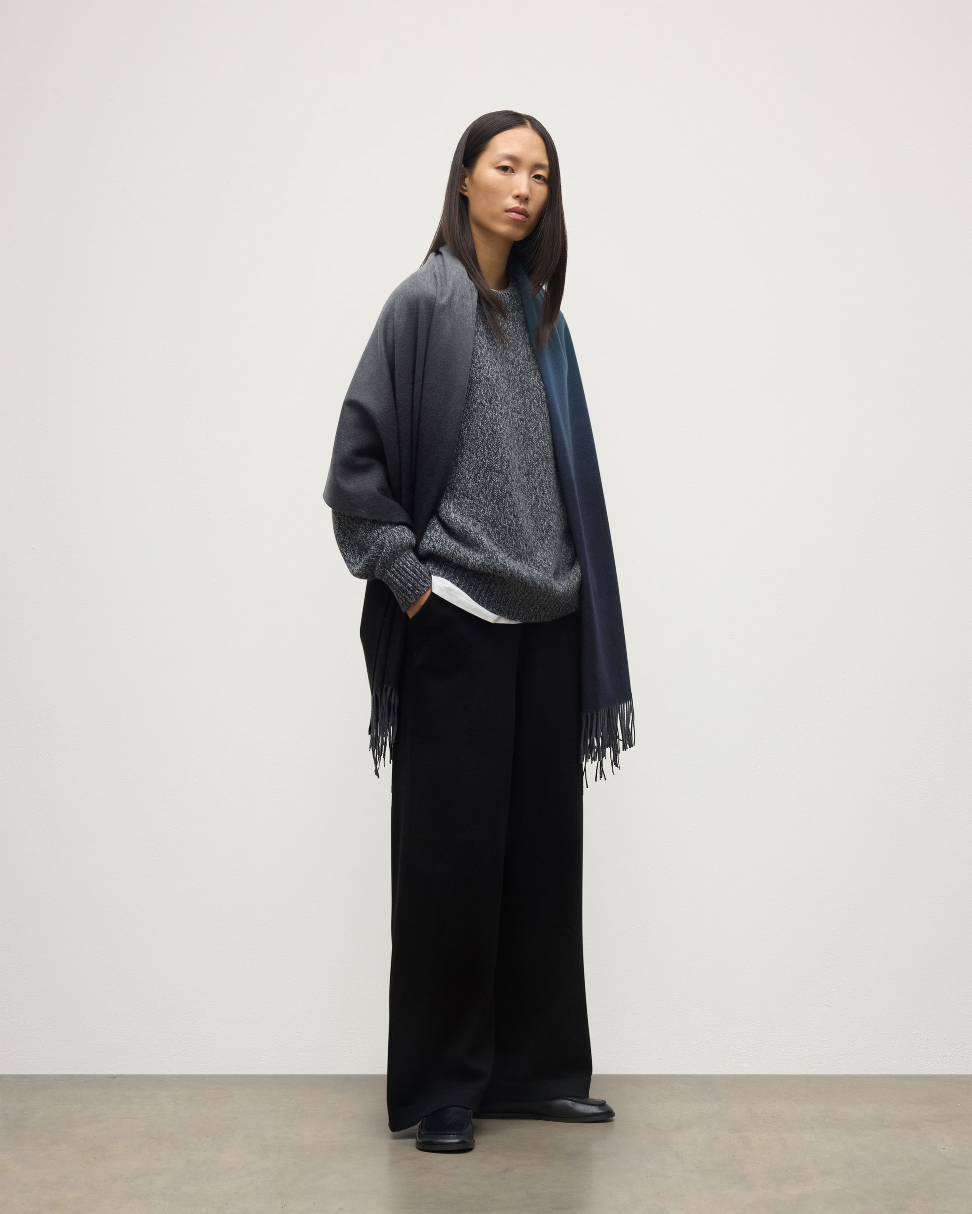 FEMALE MODEL WEARING JOHNSTONS OF ELGIN UMBRA OMBRE STOLE BLACK & NAVY 100% CASHMERE OVER BLACK & FYFE NAVY MARL CASHMERE KNITWEAR WA000056RU7302ONE