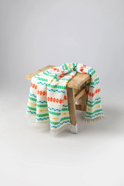 2025 Johnstons of Elgin Interiors Collection Bright Purled Fringe Children's Blanket on a wooden stool   WB002334RU7436ONE