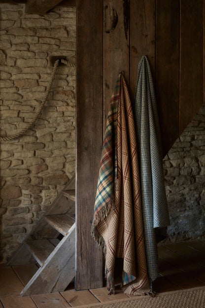 2025 Johnstons of Elgin Interiors Collection Multi check & Gunclub Windowpane Reversible Lambswool Throw hanging on a stairway next to a tweed texture blanket  WD000021RU7460ONE