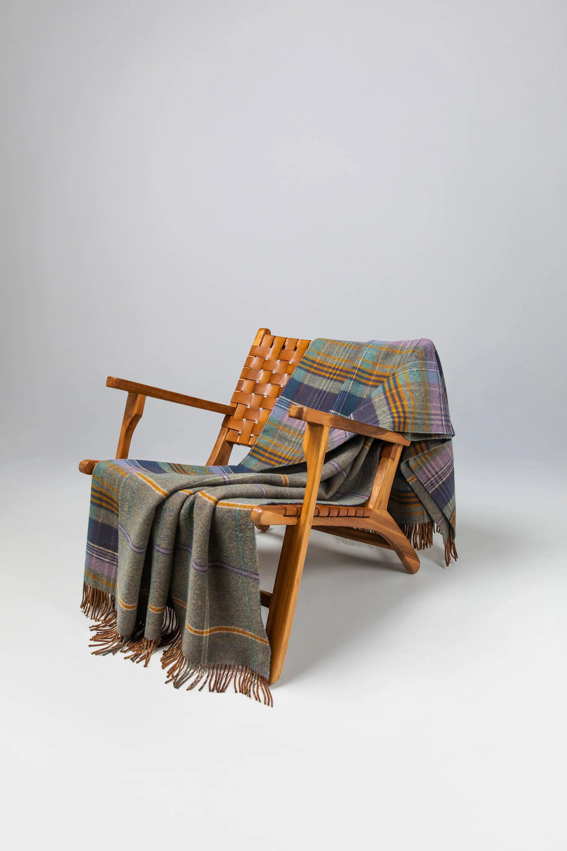 Johnstons of Elgin Blanket Collection Lovat Green Check Double Face Lambswool Throw on a wooden chair WD000021XU0332N/A