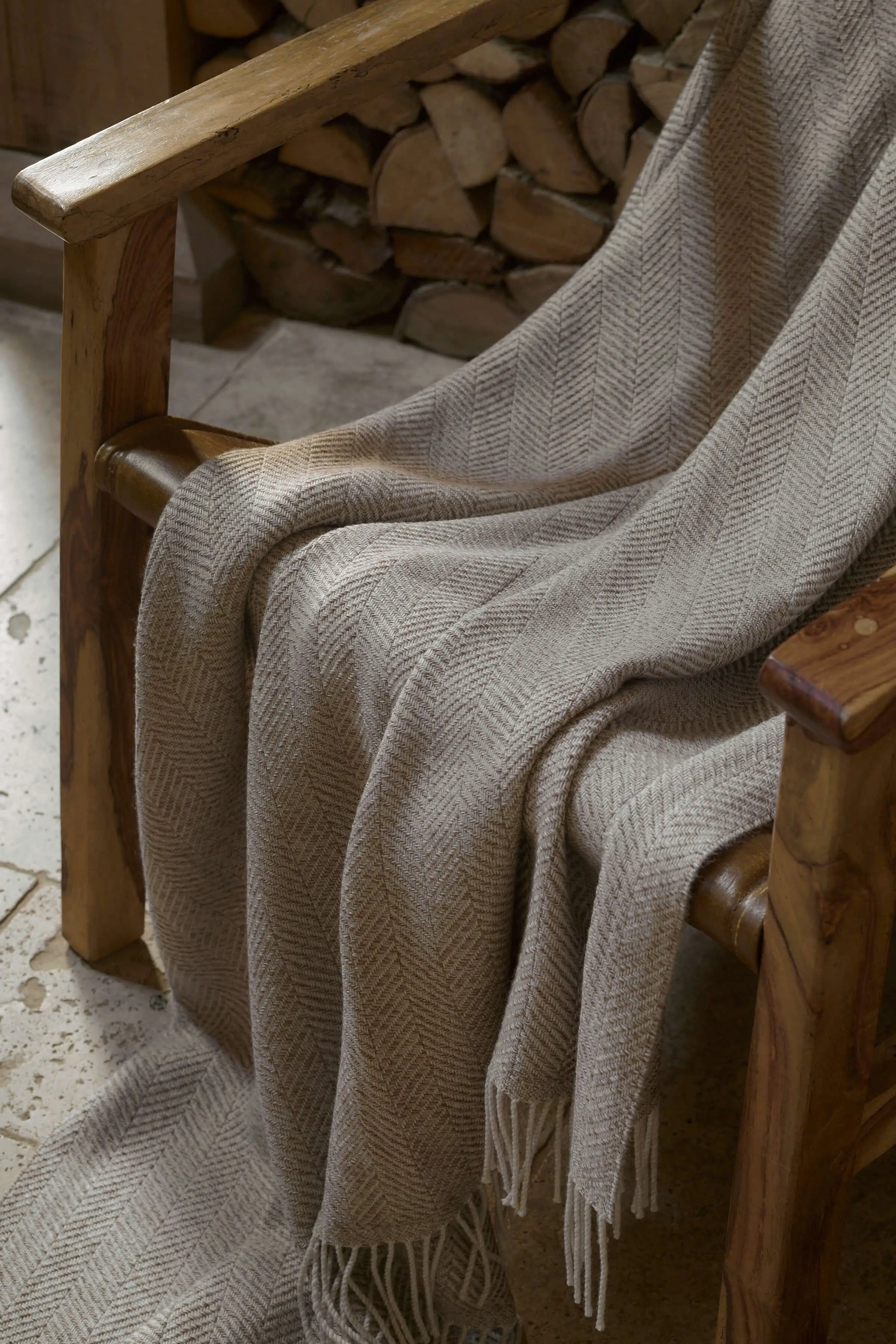 2025 Johnstons of Elgin Interiors Collection Natural Texture Herringbone Merino Throw on a wooden chair WD001221RU7455ONE