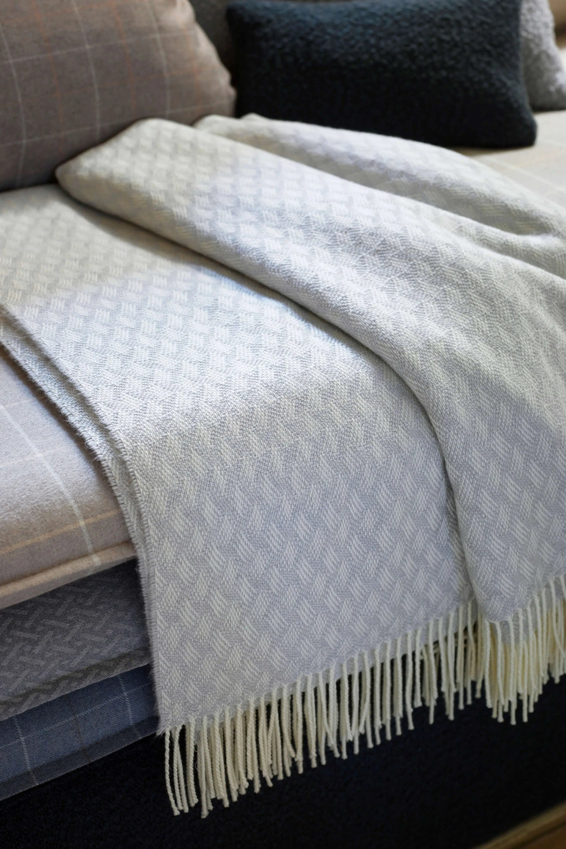 Johnstons of Elgin’s Lattice Weave Merino Bed Throw in Silver & White on bed in neutral bedroom WD001243RU7269ONE