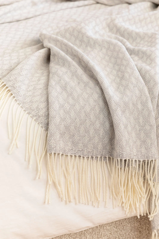 Johnstons of Elgin’s Lattice Weave Merino Bed Throw in Silver & White on bed in neutral bedroom WD001243RU7269ONE