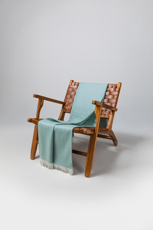 Johnstons of Elgin's Duck Egg & White Herringbone Merino Throw on brown chair on a grey background WD000010RU5835ONE