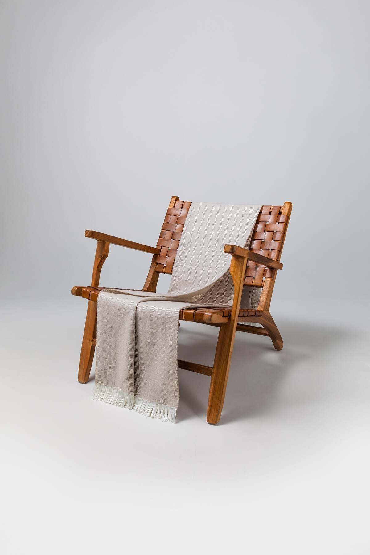 Johnstons of Elgin's Fawn & White Herringbone Merino Throw on brown chair on a grey background WD000010RU5840N/A