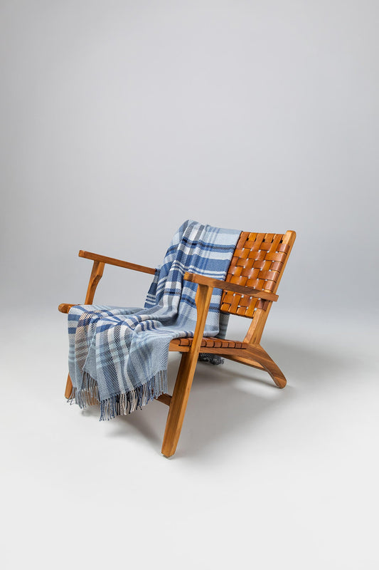 Johnstons of Elgin’s Blue & Grey Lofty Check Merino Throw on brown chair on a grey background WD001221RU6979ONE