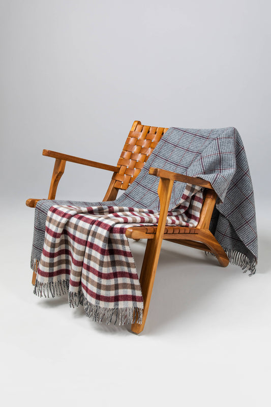 Johnstons of Elgin’s Double Face Tay Check Lambswool Throw on brown chair on a grey background WD000021XU0286N/A