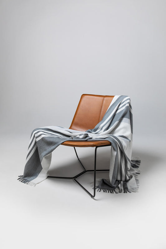 Johnstons of Elgin’s Bold Stripe Grey Merino Throw on brown chair on a grey background WD000257RU6994ONE