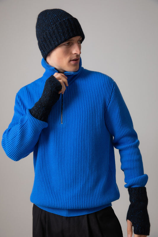 Johnstons of Elgin’s Donegal Beanie & Wrist warmers Gift Set Dark Navy on a model wearing a Orkney Blue cashmere ribbed zip neck jumper on a grey background AW23GIFTSET5C