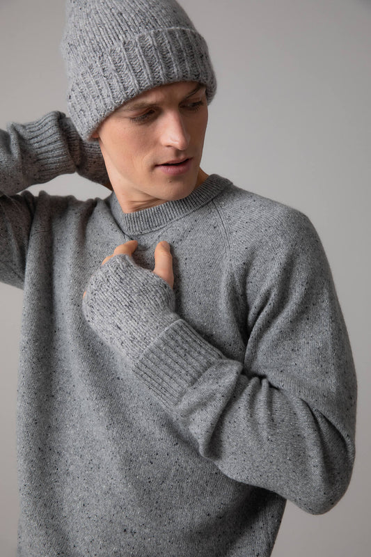 Johnstons of Elgin’s Donegal Beanie & Wrist warmers Gift Set in Light Grey on a model wearing a grey cashmere jumper on a grey background AW23GIFTSET5B