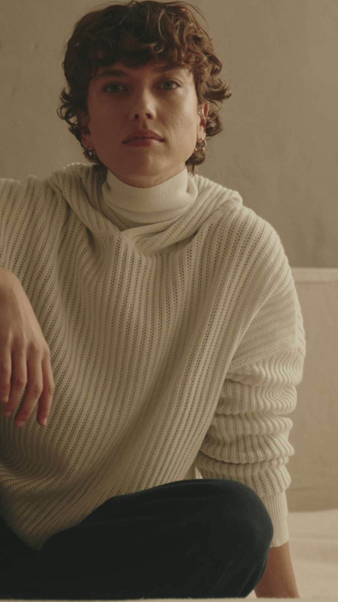 Video of Johnstons of Elgin SS25 Unisex Knitwear White Mesh Rib Cashmere Hoodie worn by a female model showing details of the knit and style  KAA05413HA0346